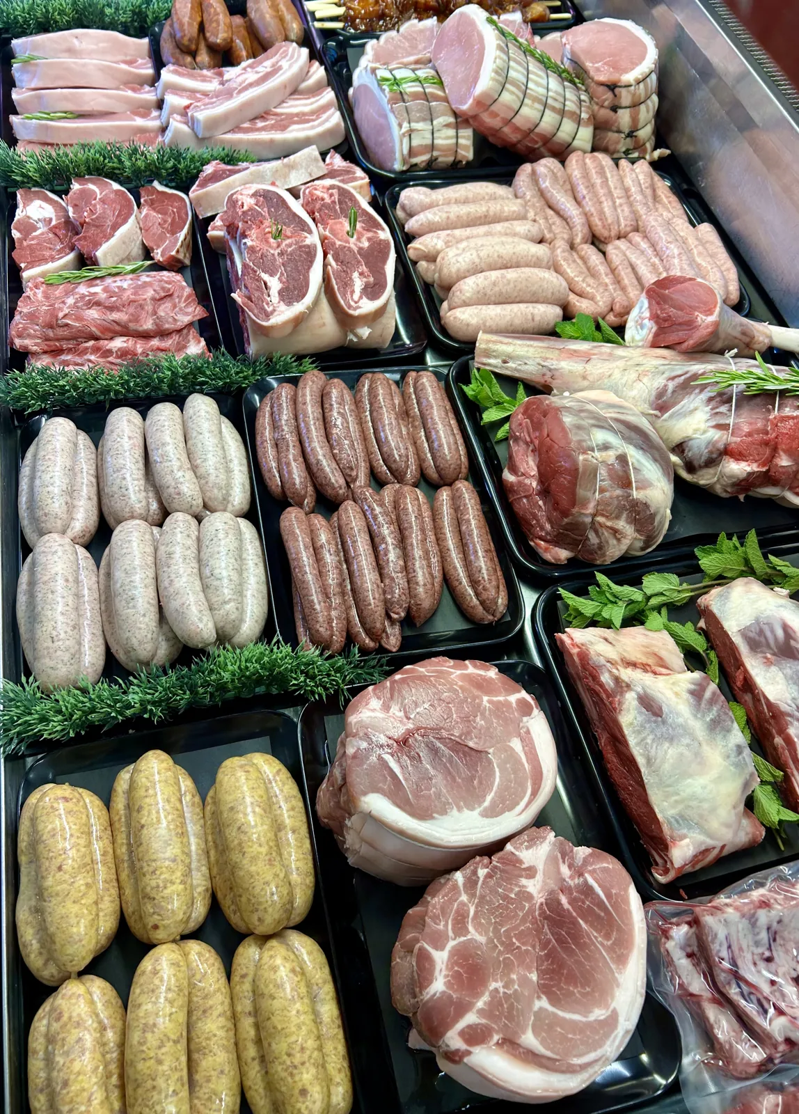 Overhead view of sausages, roasting joints and prepared dishes in the meat display