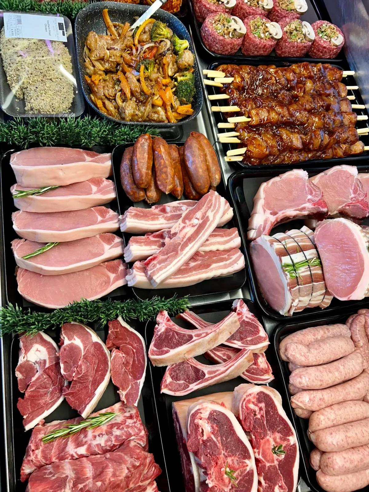 Pork cuts, lamb chops, sausages and meat skewers in the butcher’s counter, Sandbach